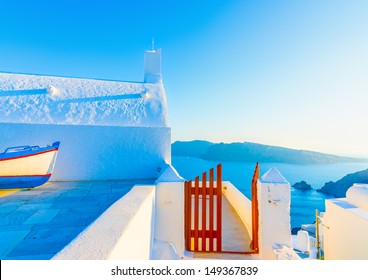 Old small white church with a fishing boat as a decoration in Oia the most beautiful village of Santorini island in Greece