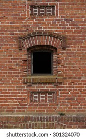 Old small window with red brick in the wall of an old warehouse.