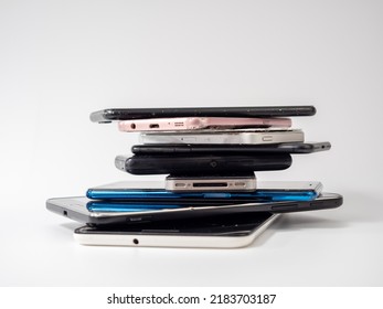 Old smartphones lie on top of each other. Stack of old mobile phones. Smartphones on a white background. - Shutterstock ID 2183703187
