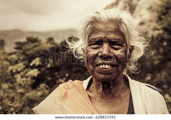 Old smiling indian woman. Elderly wrinkles. White hair and worn teeth. Location: Ella, Sri Lanka. July 2016