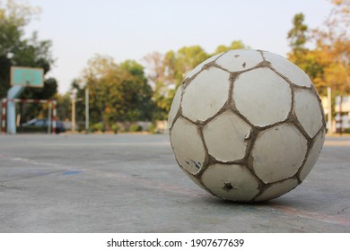 An Old Soccer Ball In The Field