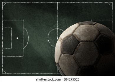 Old Soccer Ball On A Dark Green Blackboard With Football Field. Template For Sport 