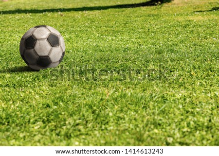 Old soccer ball on green grass with copy space,  football sport concept