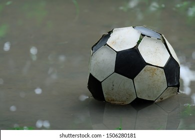 The Old Soccer Ball On Water Floor Reflected In Water.