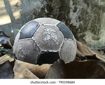 Old Soccer Ball Placed On A Leaf Near The Old Cement Water Tank.