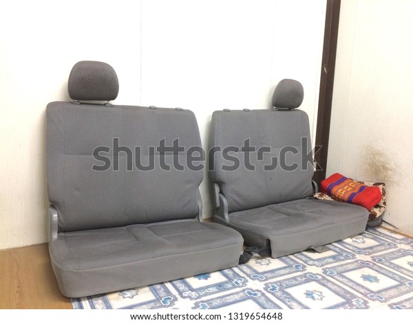 Old sofas,\
car seats, old leaning on a white\
wall