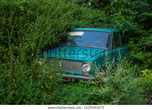 old\
Soviet car, abandoned in the weeds for your\
design