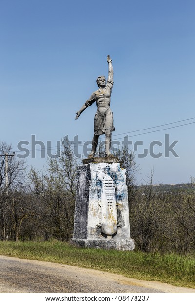 The old Soviet\
sculpture Worker and Collective Farm on road offers entry into a\
dying Ukrainian village. Old Soviet monument, Odessa. Legacy of \
Soviet period in Ukraine.