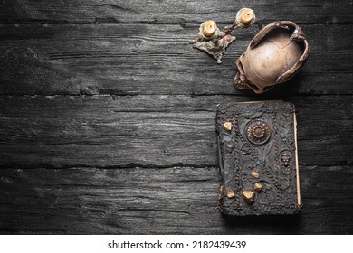 Old spell magic book and burning candle on the wooden table flat lay background with copy space. - Shutterstock ID 2182439439