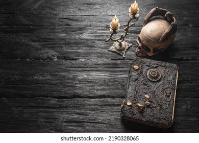 Old spell magic book and burning candle on the wooden table flat lay background with copy space. - Shutterstock ID 2190328065