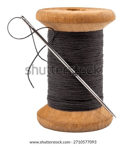 Old spool of thread and needle on a white background. Sewing accessories