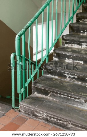 An old staircase with worn steps and rusty railings reflects years of neglect in a once vibrant home. The faded paint and chipped edges tell stories of the past and forgotten memories