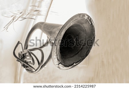 Old steampunk vintage black and white instrument photo: trumpet hanging on the wall