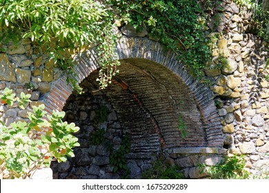 Viejo puente de piedra con vegetación en un parque