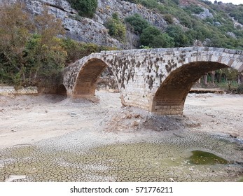 The old stone bridge over the dry Nahr-al Kalb (The Dog River) in Lebanon Beirut.  This photo was taken on the last day of dry season with rains that afternoon. - Shutterstock ID 571776211