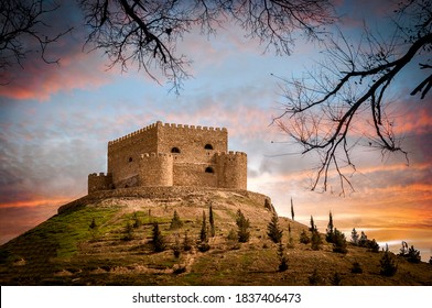 An old stone building castle over hills at sunset