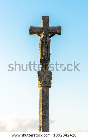 old stone cross on a blue sky