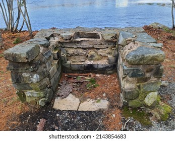 An Old Stone Fireplace Filled With Pine Needles.