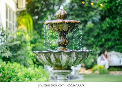 old stone fountain with dripping water in the park. - Powered by Shutterstock