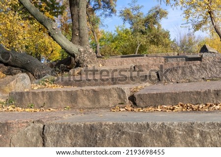 Old stone stairs in autumn. Staircase in steps among yellow foliage. Footpath nature among trees with golden leaves. Way outdoors. Autumn reflections. Fall bright.