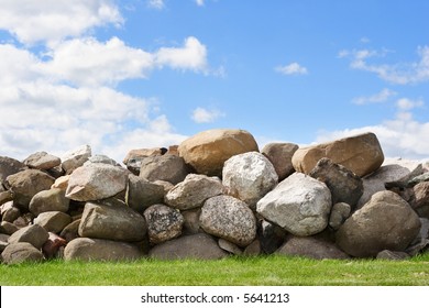 An old stone wall against a blue cloudy sky