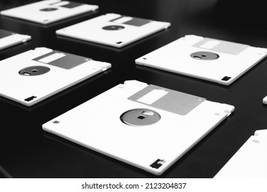 Old storage floppy disks lying on a dark table. Photography about technology, computing and history.
