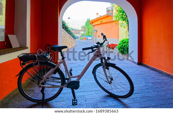 Old street with bicycle parked in Vintage\
style. Bike public vehicle tourism. Summer background. Lifestyle\
design. Side view. Travel background. Traditional european sport.\
Spring vacation.