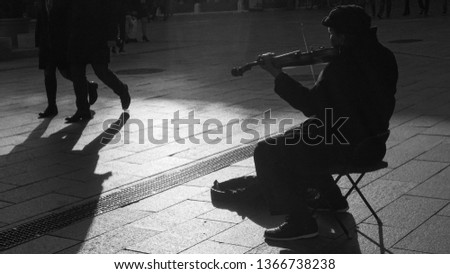 Old street musician playing his violin.
