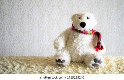 An Old Stuffed Polar Bear On The Sofa.