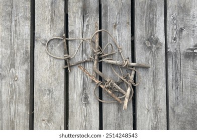 an old sturdy rope rope lies on an ancient wooden floor made of gray planks, an old marina for mooring a ship and access to the port, a convenient cable for parking boats of yacht boats - Powered by Shutterstock