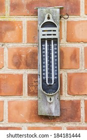 Old style analog maximum minimum mercury thermometer on a brick wall