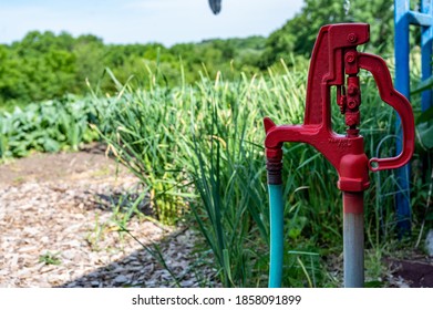 Old style mechanical self draining hydrant in blurred rural garden setting