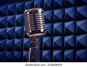 Old style mic, in an isolated recording studio booth. Retro, professional equipment on a music template, with copy space for text