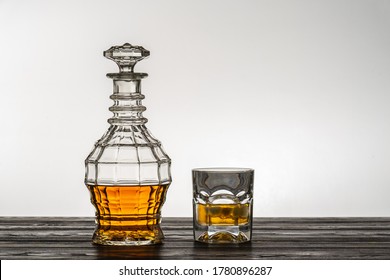 Old Style Vintage Whiskey Decanter And A Glass On Wooden Table