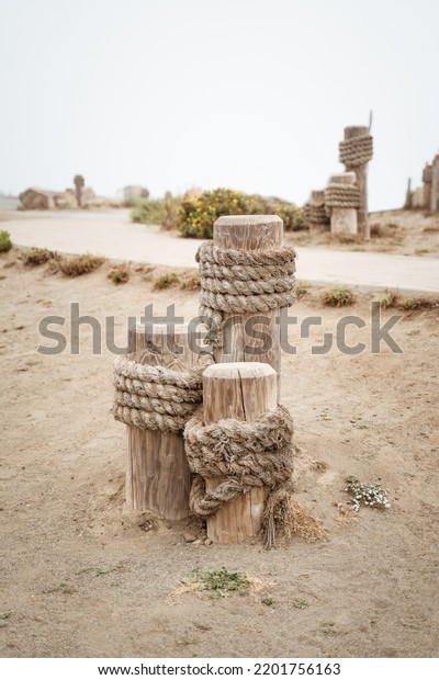 old style Wooden Mooring post\
with rope in Morro bay California. Aesthetic travel\
background