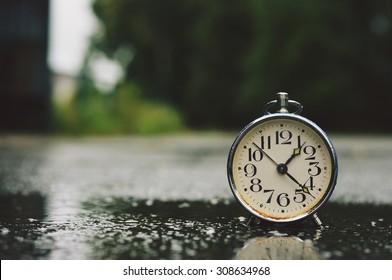 Old Stylish Alarm Clock On The Street In The Rain