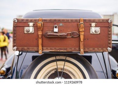 Old Suitcase Over The Wheel, On The Trunk Of An Old Car 