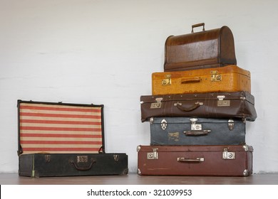 Old suitcase and a sewing machine in a case against a background of bright walls