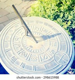 Old Sun Clock Dial In A Garden