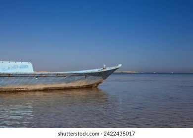 Old sunken fishing boat aground in the red sea in Egypt against the blue sky