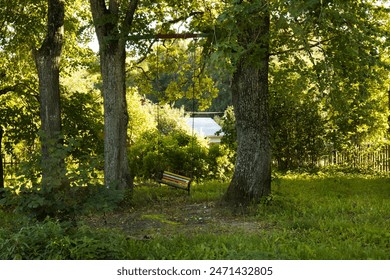 An old swing weighs between two trees. Colorful homemade swing in the park. - Powered by Shutterstock