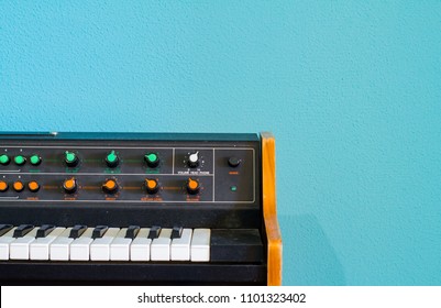 Old synthesizer with colorfull switches on blue background