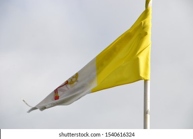 Old Tattered Papal Flag Blowing On A Story Day