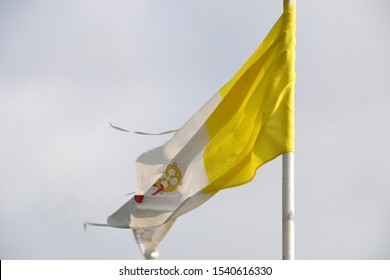 Old Tattered Papal Flag Blowing On A Story Day