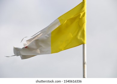 Old Tattered Papal Flag Blowing On A Story Day