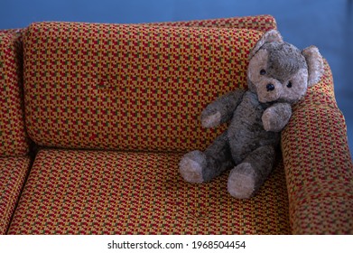 Old Teddy Bear Sitting On An Old Bed