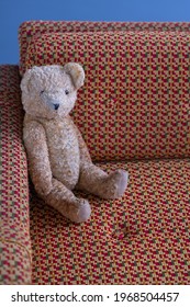 Old Teddy Bear Sitting On An Old Bed