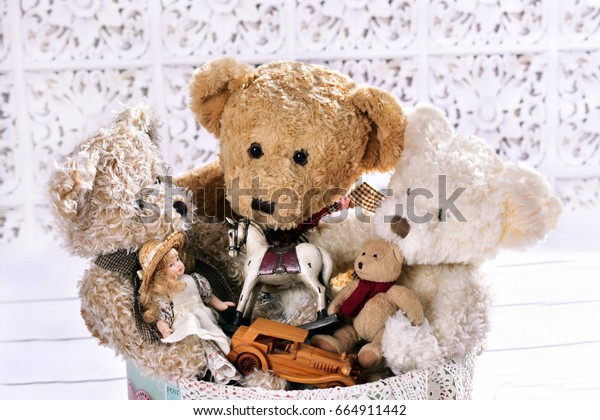 old teddy bears and other toys in round box on\
white floor
