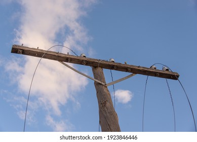 An Old Telephone Pole With Broken Wires