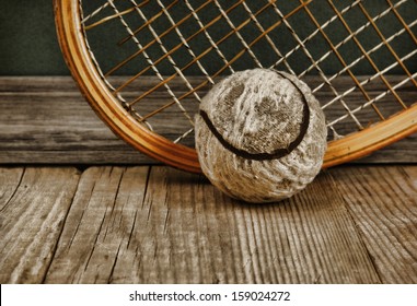 Old Tennis Ball And Racket On A Wooden Floor